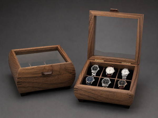Walnut watch boxes with glass lids, open box showing six watches on velvet cushions
