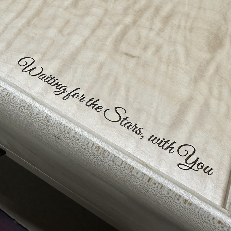 "Waiting for the Stars, with You" engraved in script on a curly maple jewelry box lid