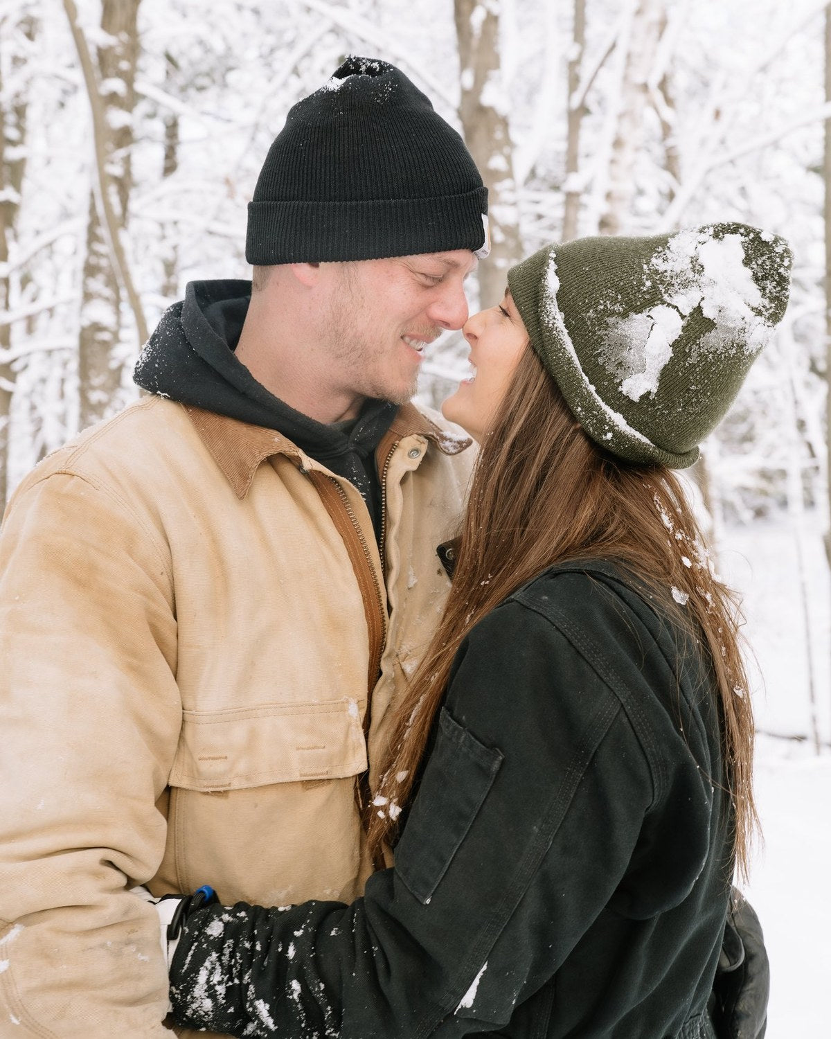 A couple smiling nose to nose in the snow