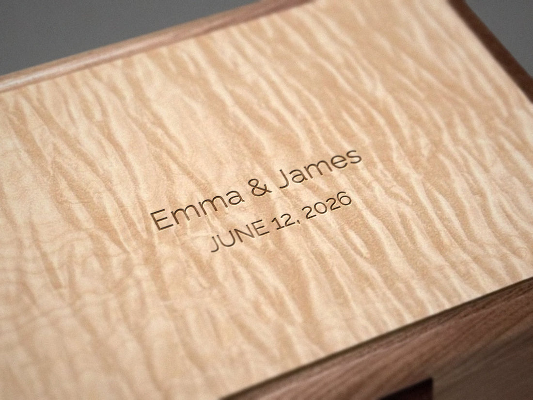 Centered engraving on the top of a walnut jewelry chest with a curly maple lid