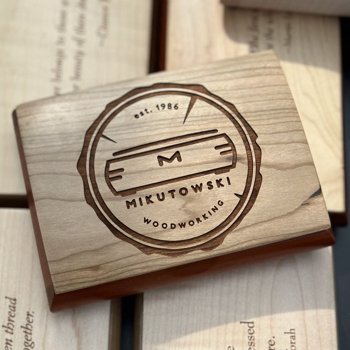 Mikutowski Woodworking logo laser-engraved on a cherry box lid