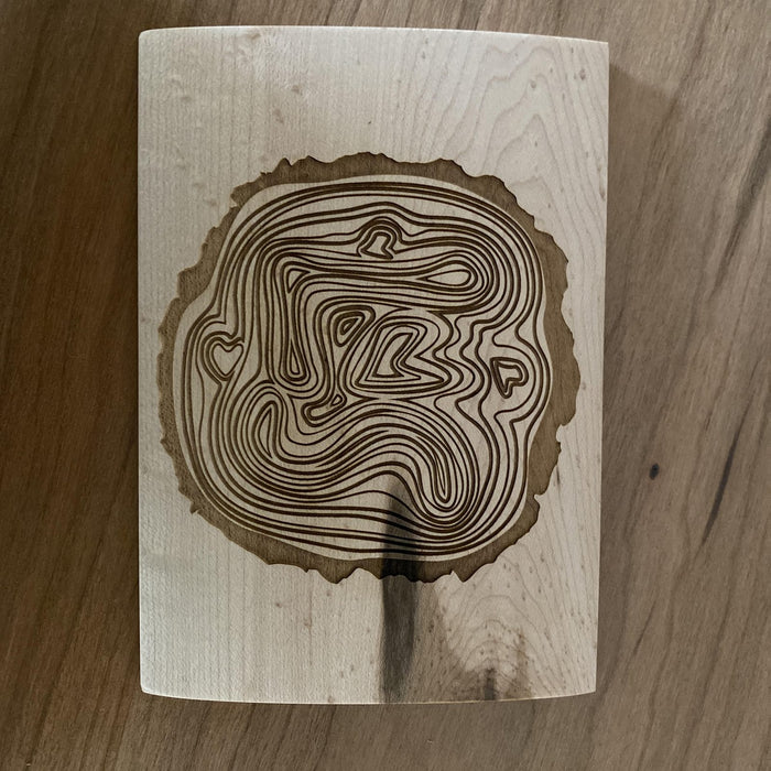 Custom tree-ring wedding logo engraved on a maple lid