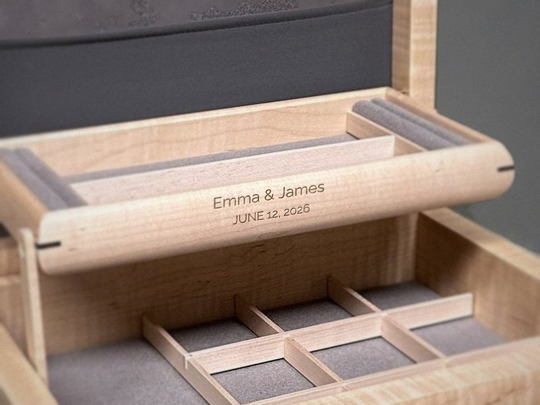 Centered engraving on the front of the self-rising tray of a curly maple jewelry box